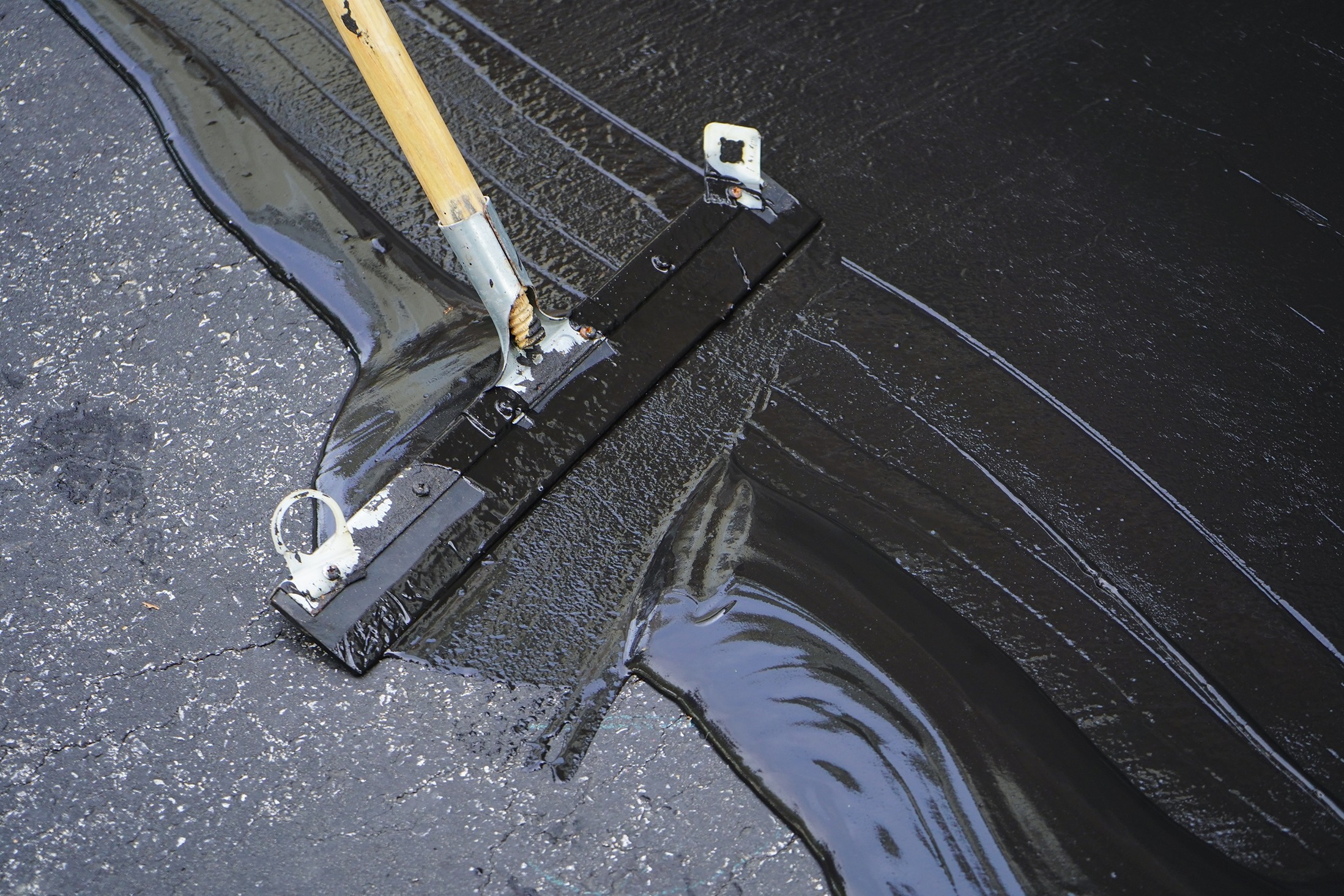 David’s Lawn Care seal coating in Valparaiso driveway